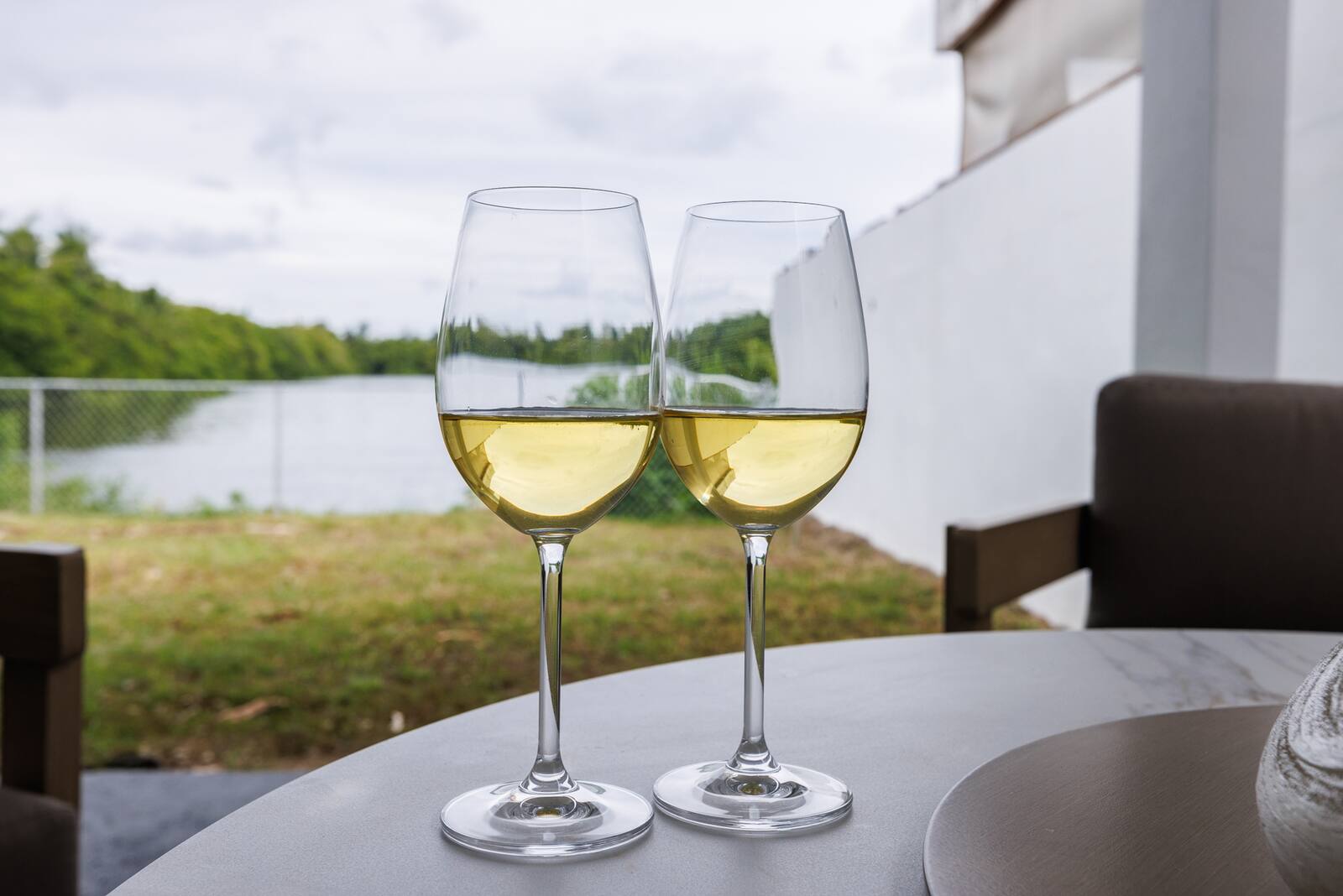 Two glasses of wine with the lagoon behind